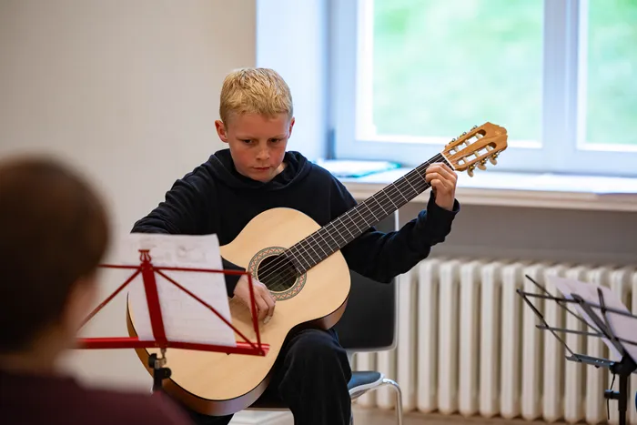 Fynn Morasch spielt Gitarre während eines Konzerts der Musikschule Volmetal in der Villa am Park.