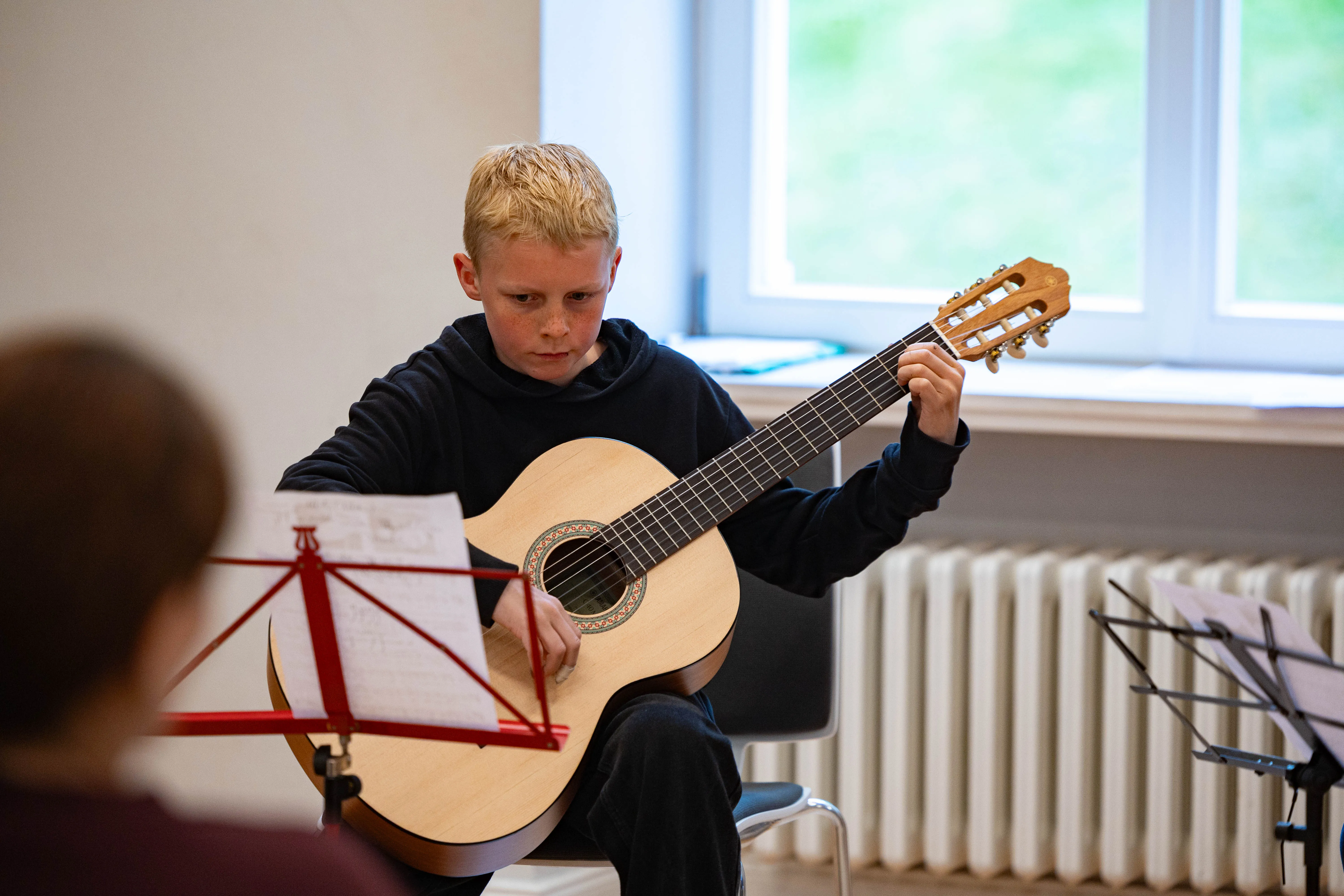 Fynn Morasch spielt Gitarre während eines Konzerts der Musikschule Volmetal in der Villa am Park.