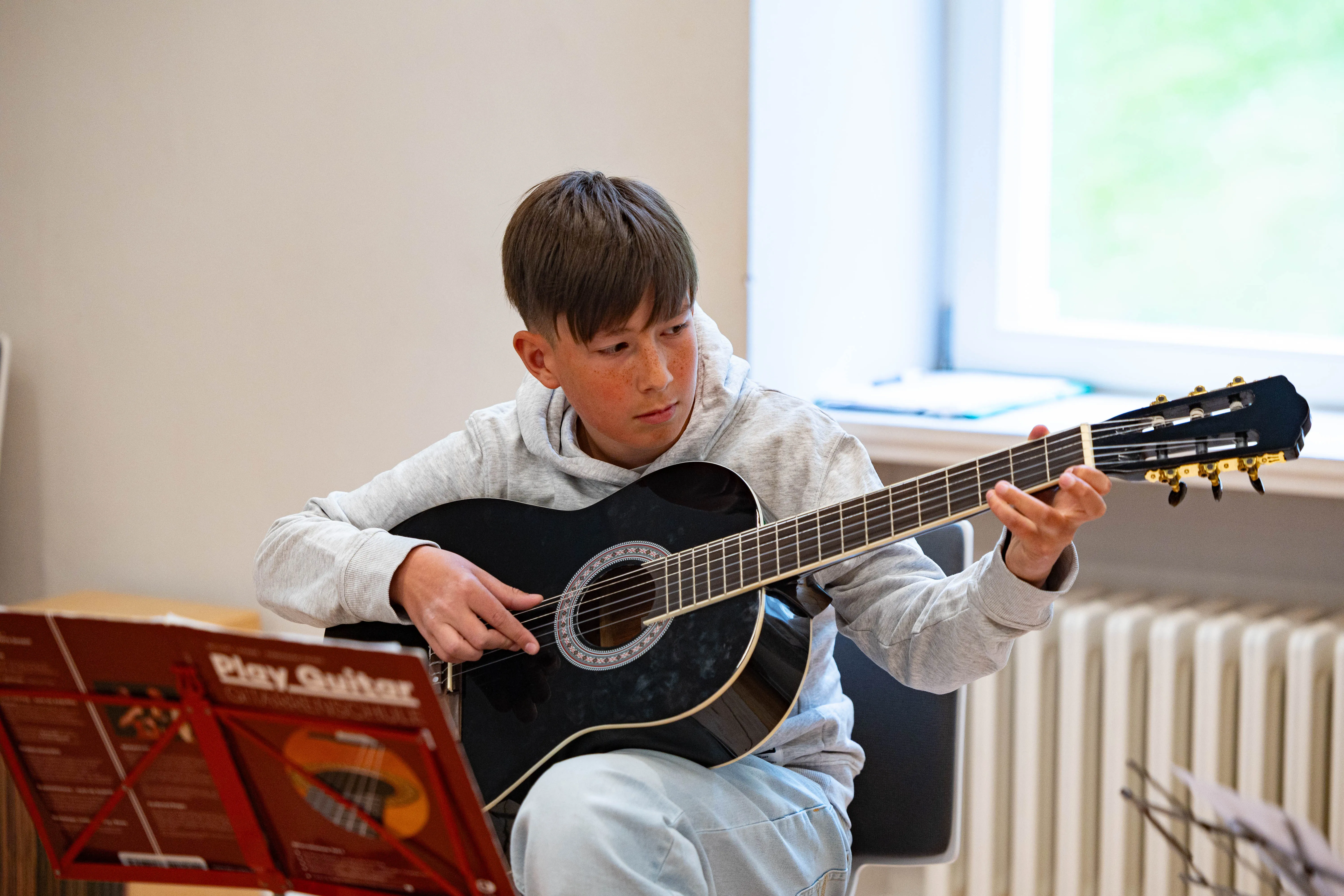 Nuri Sijamic spielt Gitarre während eines Auftritts der Musikschule Volmetal in der Villa am Park.