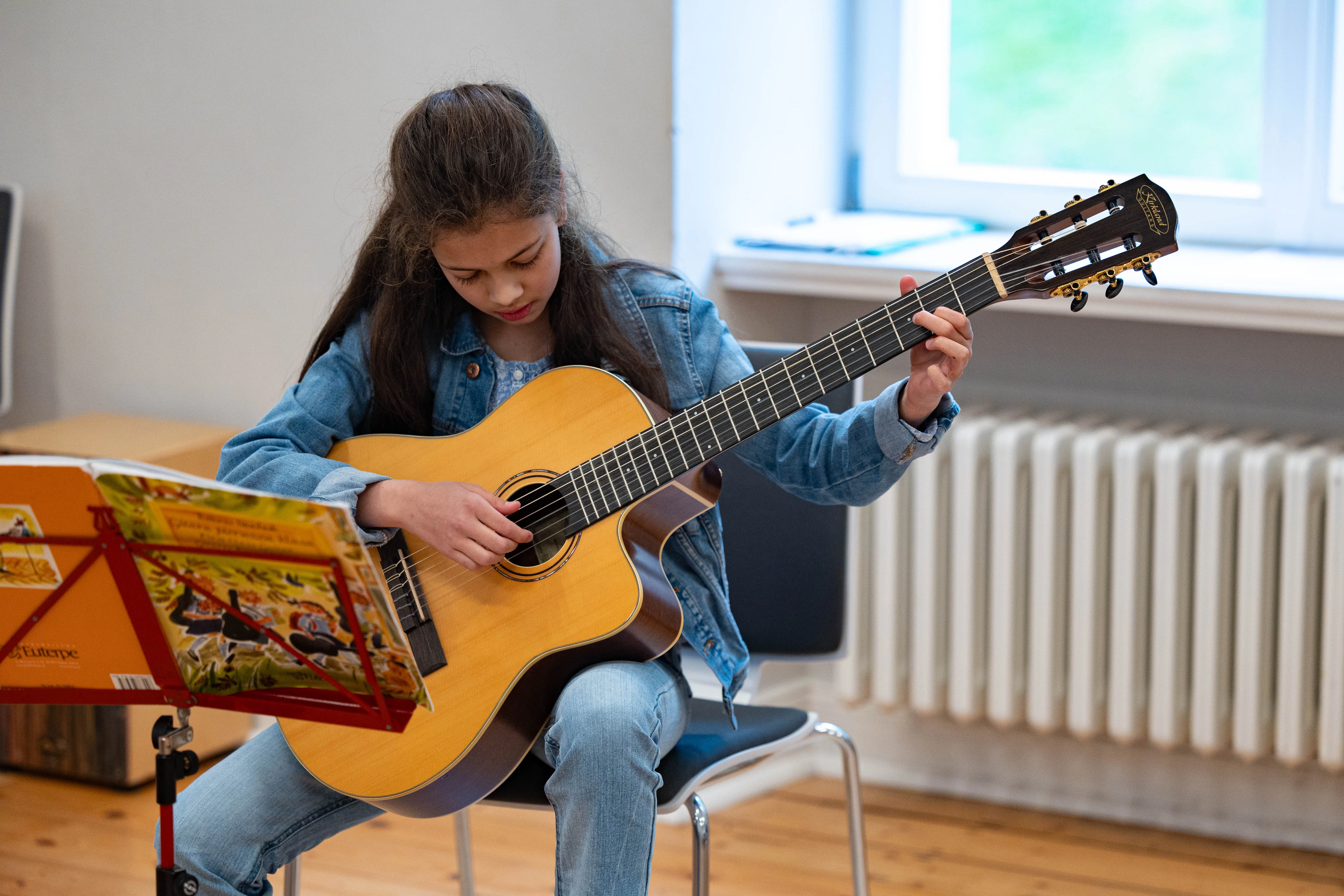 Leni Bärenwald spielt Gitarre während eines Auftritts der Musikschule Volmetal in der Villa am Park.