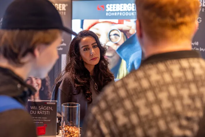 Eine Frau im Gespräch mit zwei Personen an einem Stand von Seeberger Rohrprodukte.
