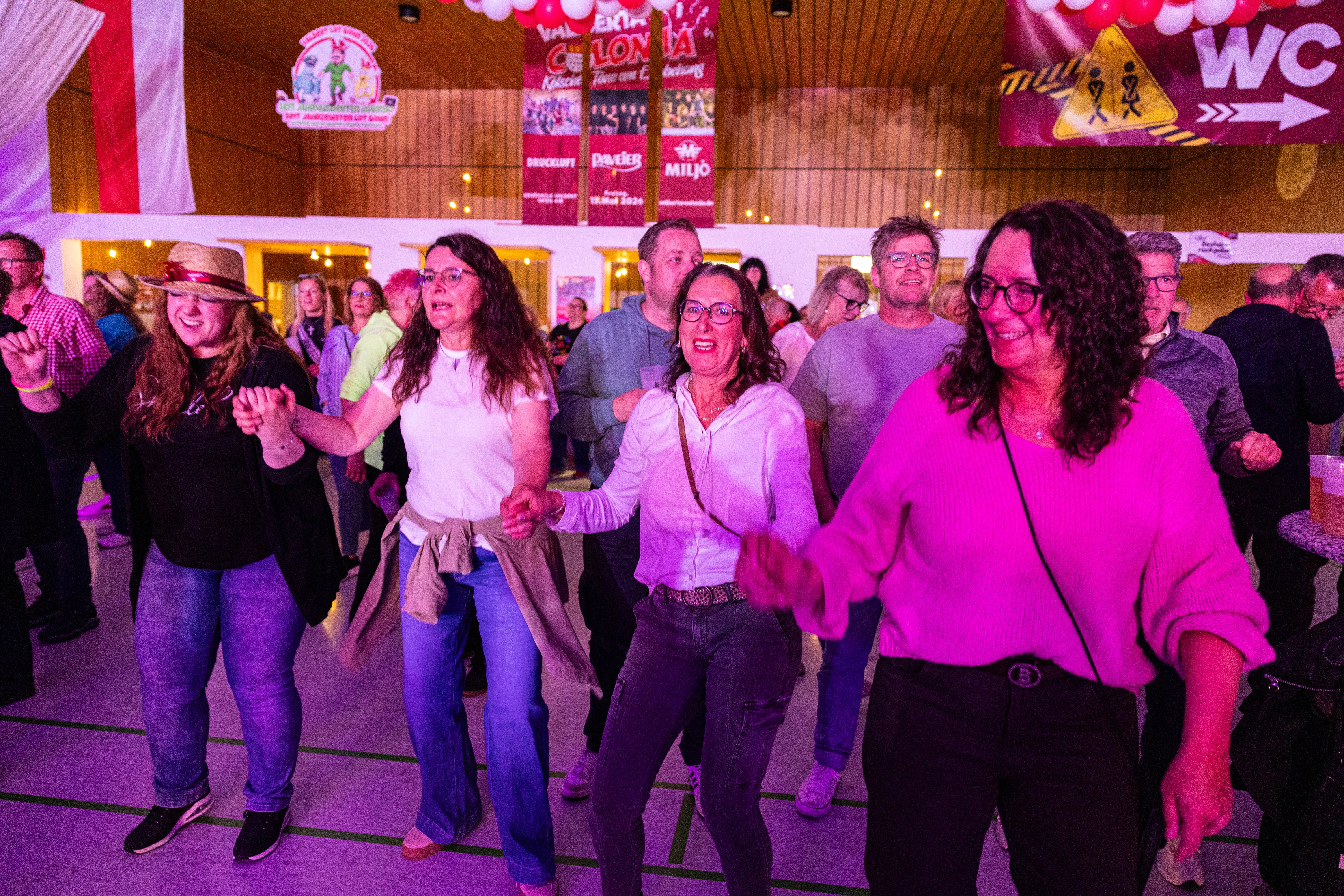Tanzende Menschen feiern auf dem Kölschmusikfestival „Valberta Colonia“ in einer hell erleuchteten Halle.