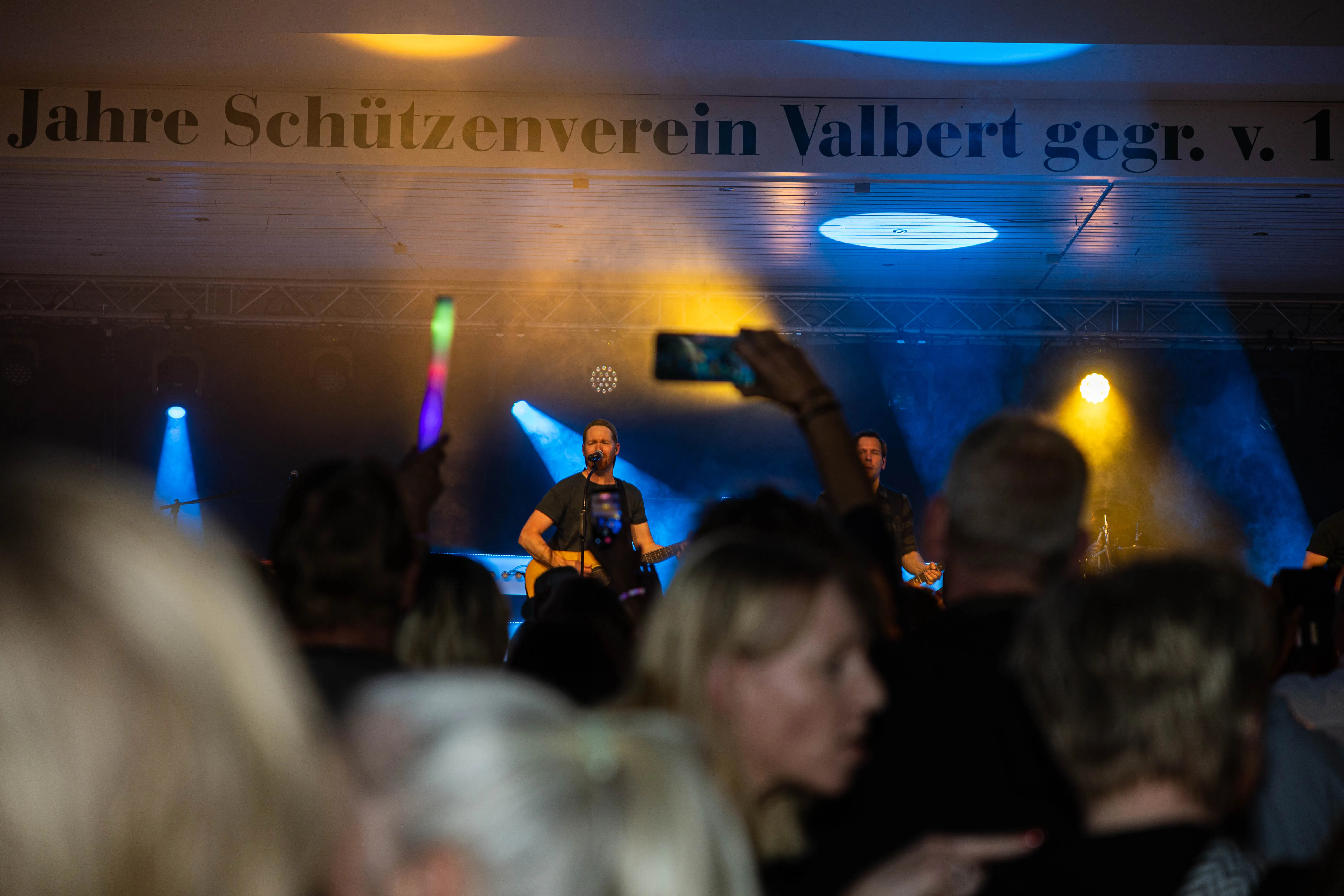 Band spielt vor Publikum in einem Zelt, im Hintergrund Banner mit Aufschrift „Jahre Schützenverein Valbert gegr. v.“