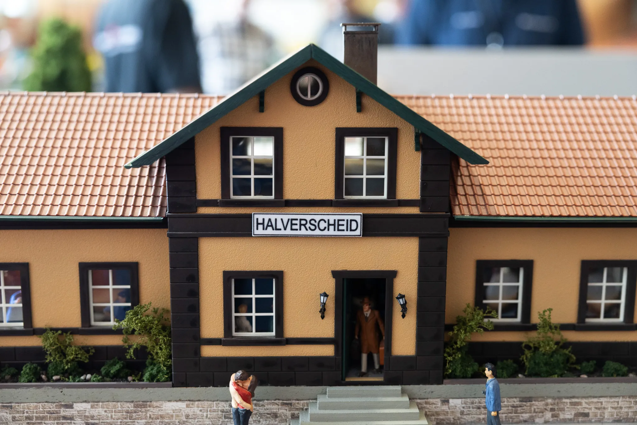Modell eines Bahnhofsgebäudes mit dem Schriftzug „Halverscheid“. Vor dem Gebäude stehen mehrere Modellfiguren.