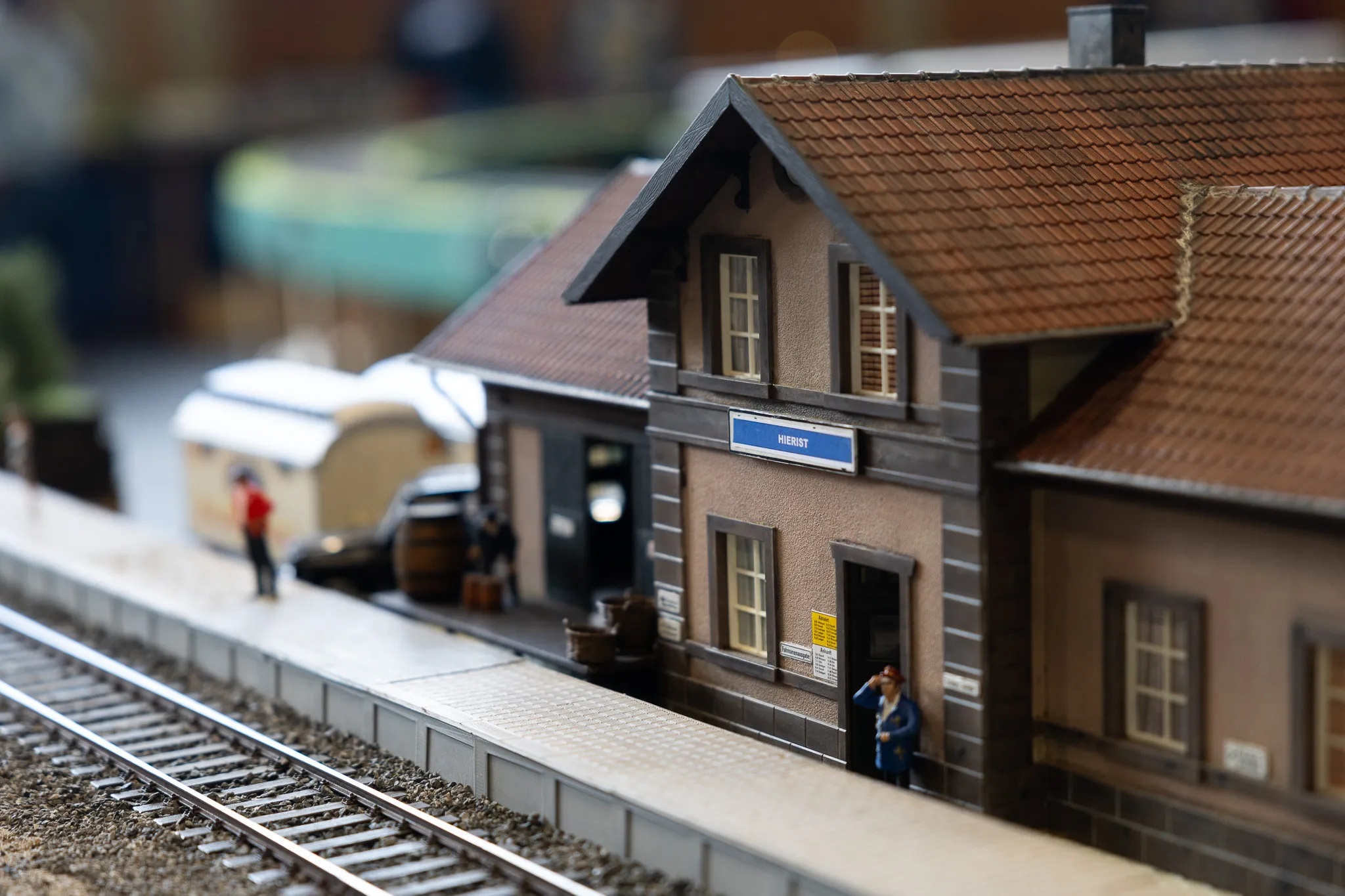Modell eines Bahnhofsgebäudes mit dem Schriftzug „Hierst“ und einer Person im Vordergrund.