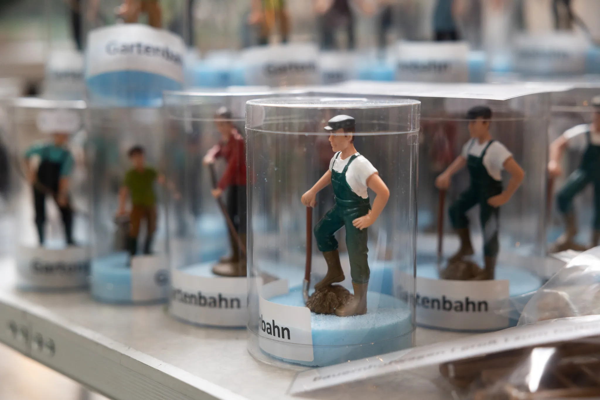Detailaufnahme einer Modellfigur eines Arbeiters mit Schaufel in einer Plastikvitrine auf einer Modellbahn-Ausstellung.