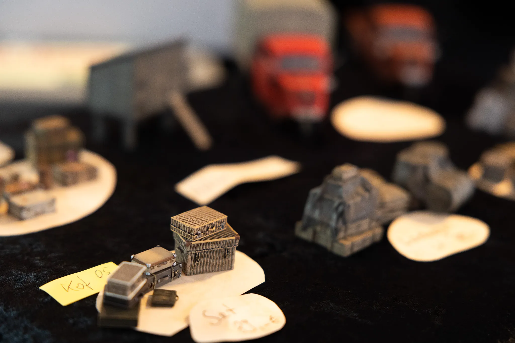 Miniaturmodelle von Gebäuden und Industrieanlagen stehen auf weißen Unterlagen und werden mit gelben Zetteln beschriftet.