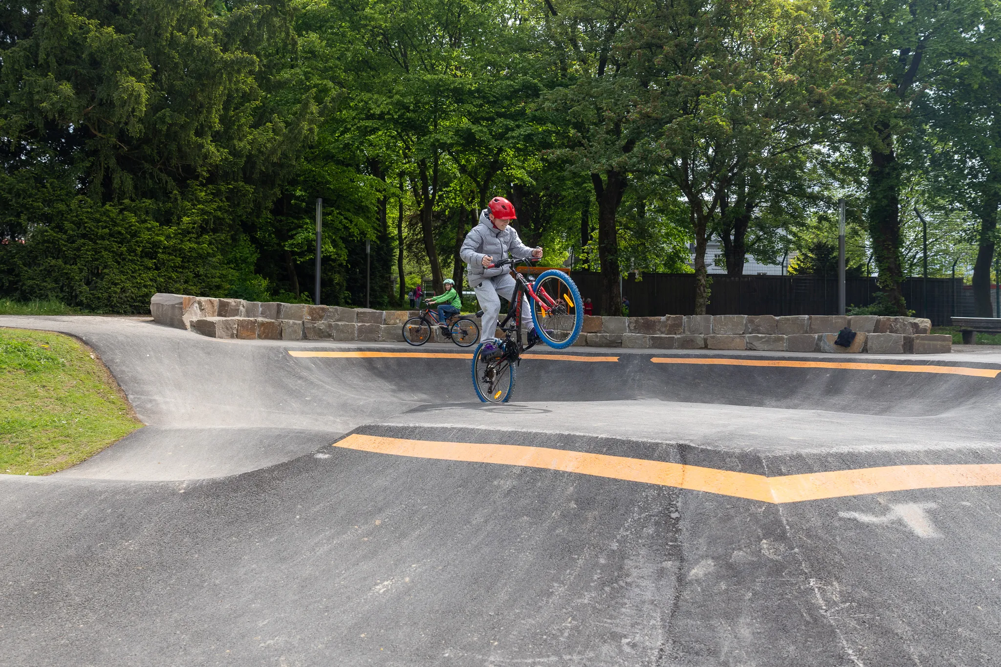 Ein BMX-Fahrer springt mit seinem Fahrrad auf einem Pumptrack im Lüdenscheider Stadtgarten in der Luft.