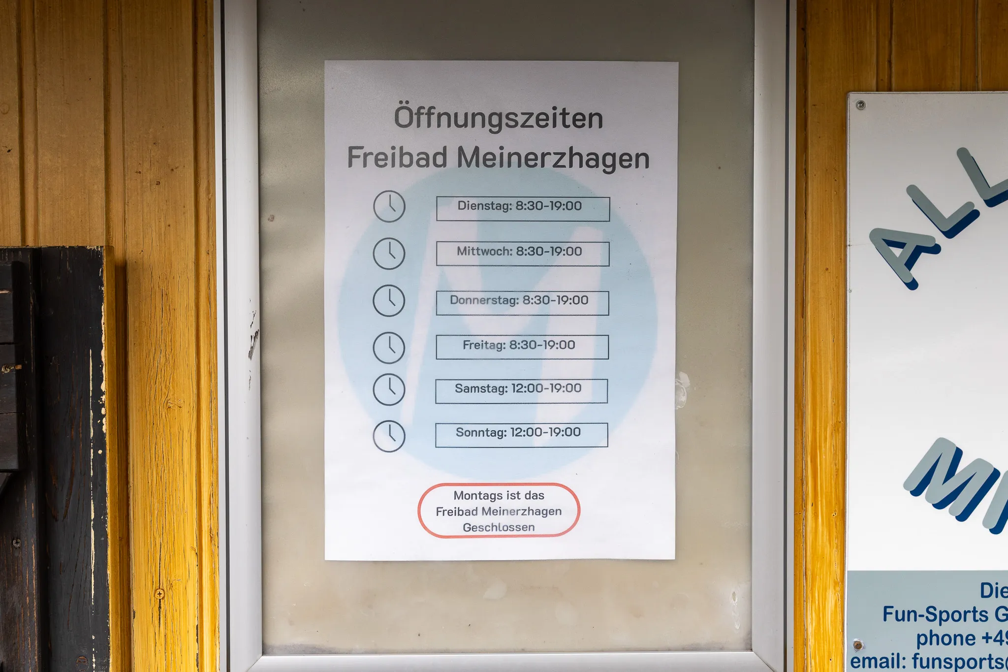 Aushang mit den Öffnungszeiten des Freibads Meinerzhagen: Dienstag bis Freitag 8:30–19:00 Uhr, Samstag und Sonntag 12:00–19:00 Uhr, montags geschlossen.