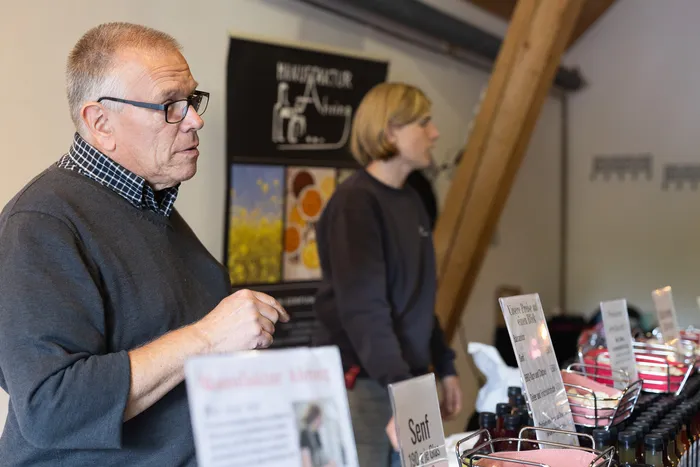 Ein Mann und eine Frau stehen an einem Verkaufsstand mit Produkten der Manufaktur Alving.