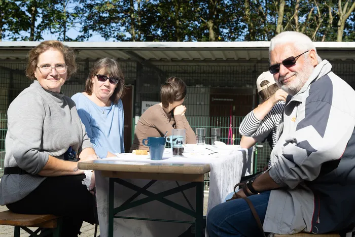 Eine Gruppe von Menschen sitzt an einem Tisch im Freien während der Herbstwanderung des Tierheims Dornbusch.