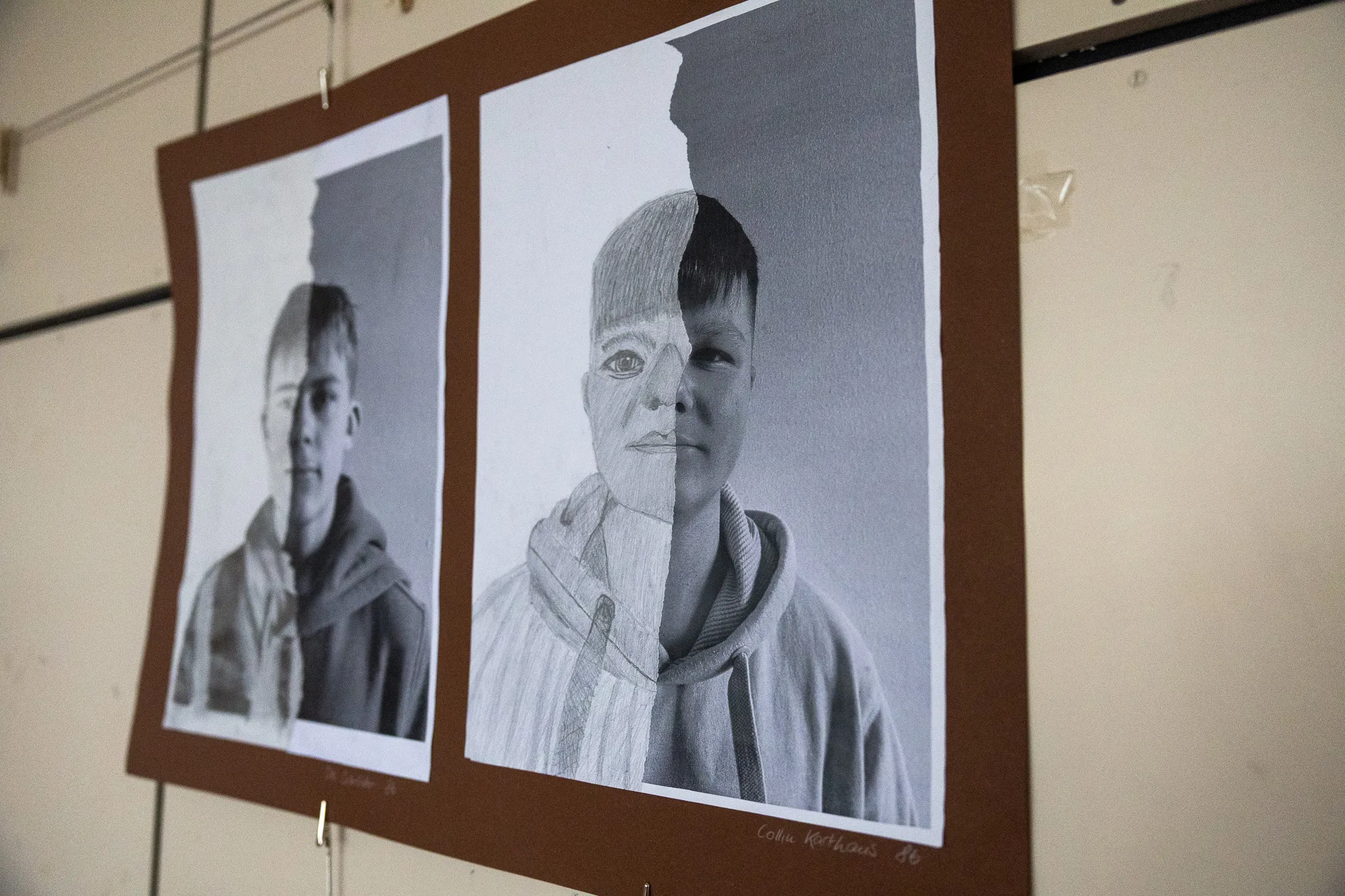 Zwei Bleistiftporträts eines Jugendlichen, wobei jedes Porträt nur eine Gesichtshälfte zeigt und die andere Hälfte leer bleibt, hängen nebeneinander an einer hellen Wand.