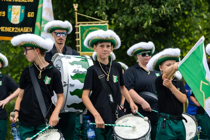 Mitglieder der Meinerzhagener Schützengilde in schwarzen Poloshirts und weißen Hüten spielen Trommeln.