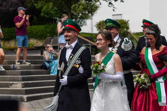 Stefan Schneider in schwarzer Uniform und grüner Mütze steht neben einer Frau in weißem Kleid bei der Feier der Meinerzhagener Schützengilde.