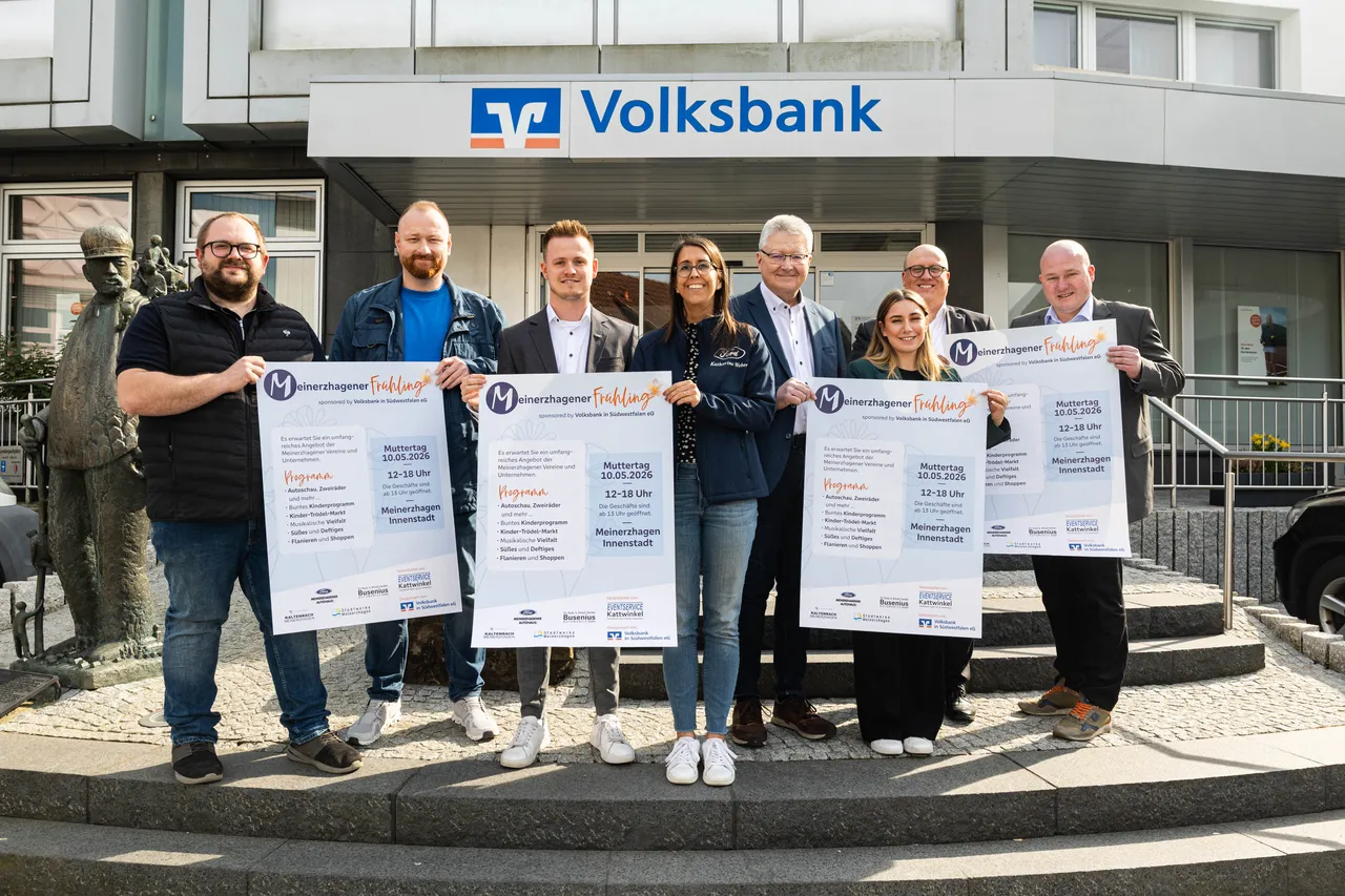 Acht Personen halten Plakate mit dem Aufdruck „Meinerzhagener Frühlingsfest“ und dem Datum 10.05.2026 hoch.