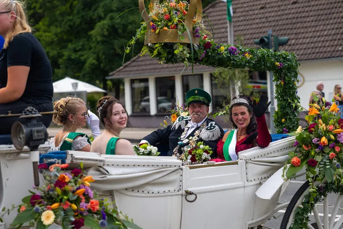 Stefan Schneider in Uniform sitzt mit weiteren Personen in einer blumengeschmückten weißen Kutsche.