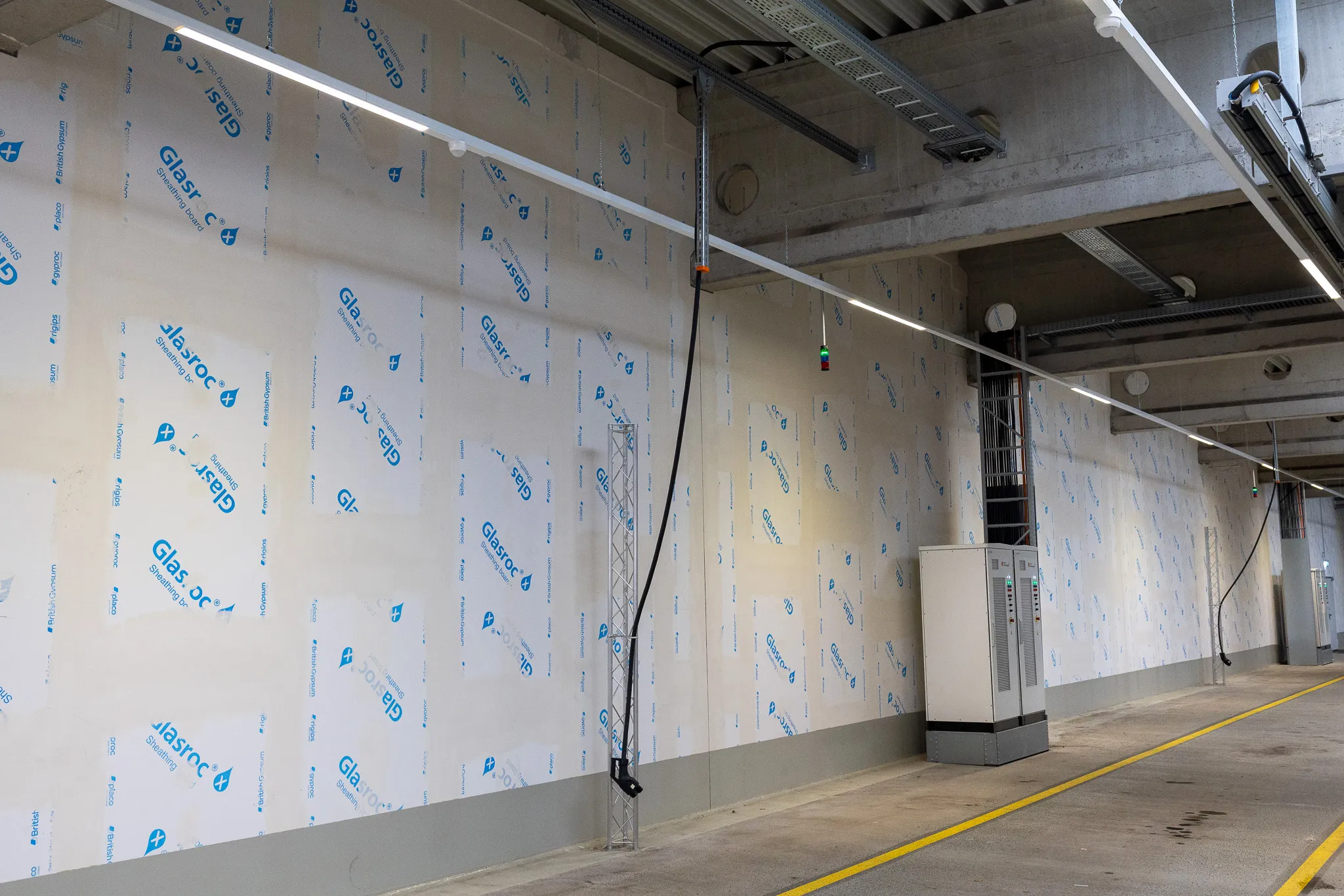 Eine Ladestation für Elektrobusse in einer modernen Betriebshalle mit hellen Wänden und Decken.