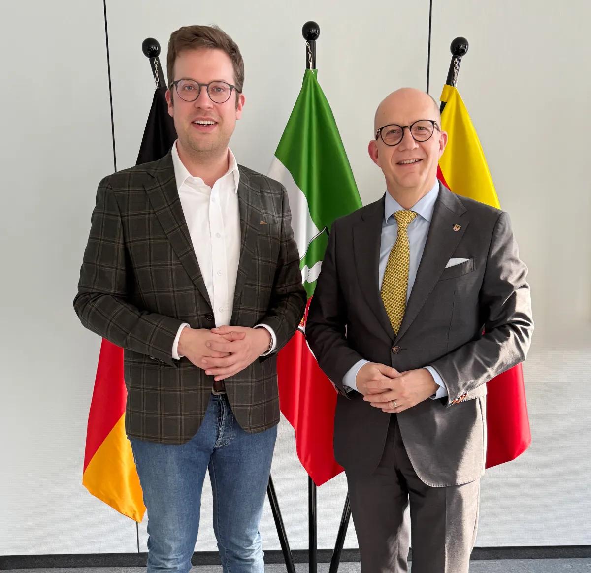 Landrat Ralf Schwarzkopf und Bundestagsabgeordneter Florian Müller stehen im Kreishaus Lüdenscheid vor den Flaggen von Deutschland und Italien zusammen.