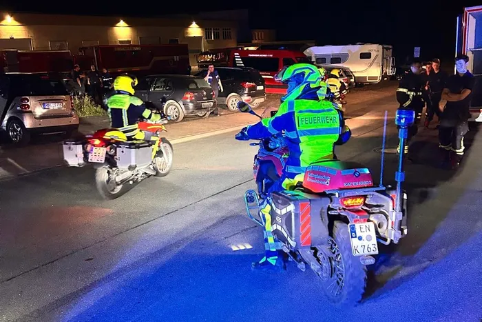Feuerwehrleute in neongrüner Warnkleidung auf Motorrädern und einem Quad bei einem nächtlichen Einsatz.