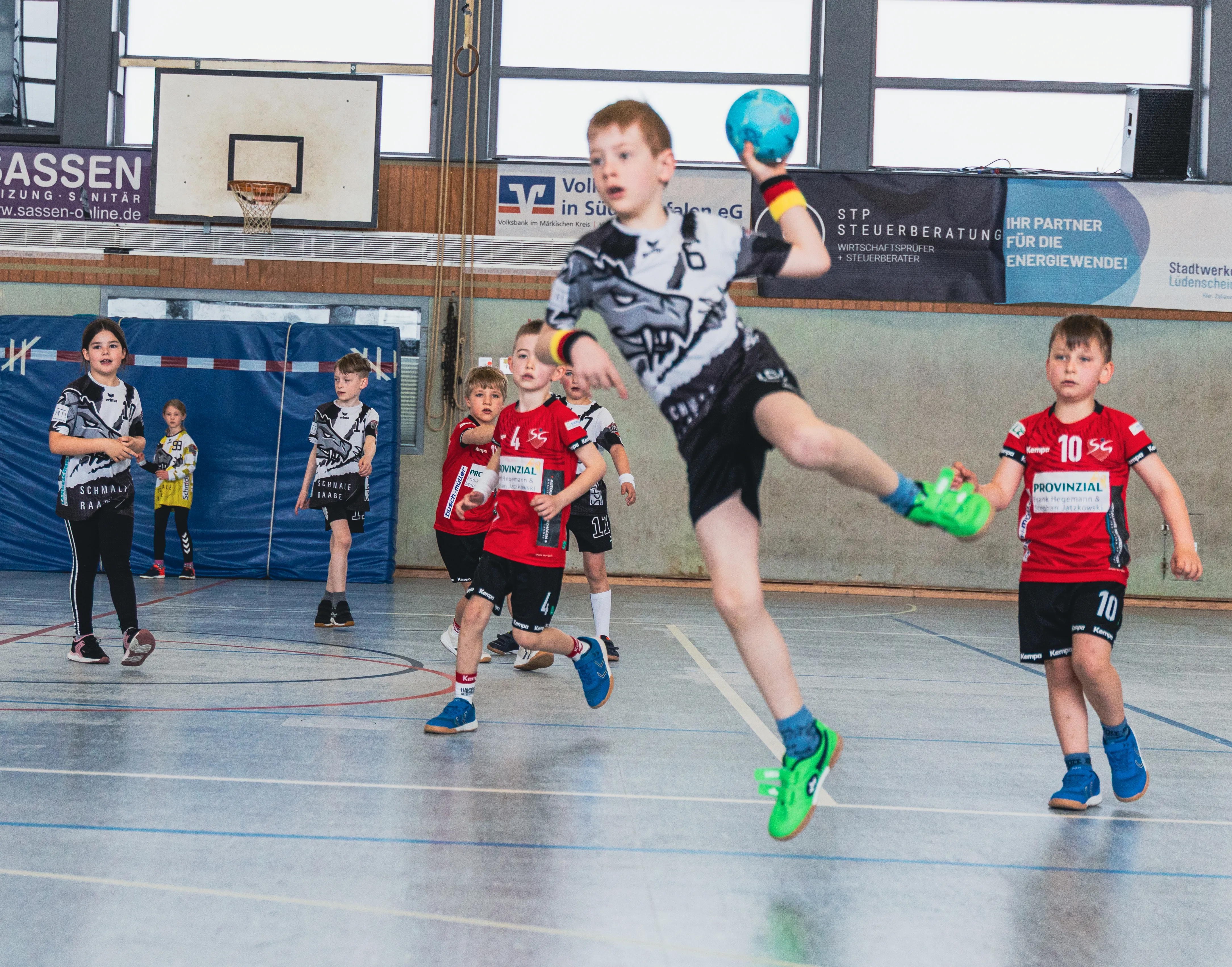 Handballspieler der F-Jugend im Spiel, ein Spieler wirft den Ball während eines Spielfestes der SGSH Dragons.