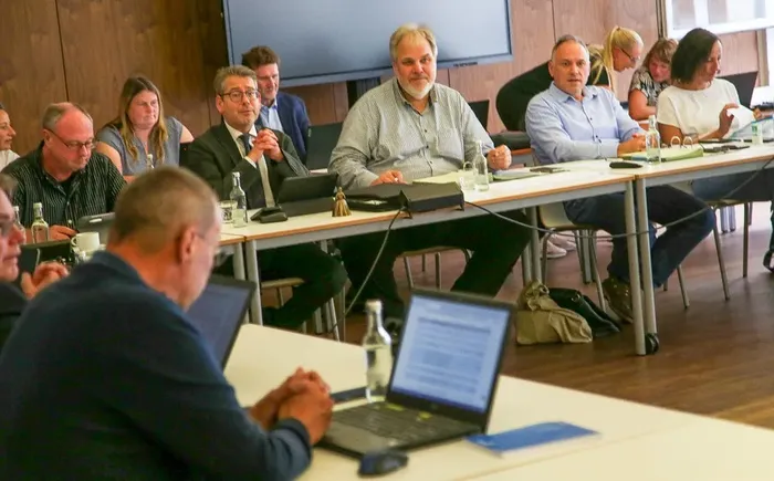 Teilnehmer einer Sitzung des Haupt- und Personalausschusses sitzen an Tischen in einem Konferenzraum.