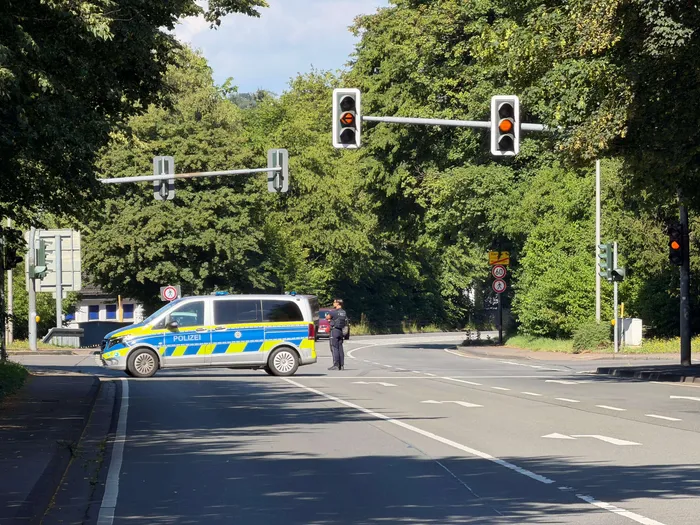 Polizeiauto blockiert eine Kreuzung auf der gesperrten Bundesstraße B54 in Meinerzhagen nach Beschädigung einer Gasleitung bei Bauarbeiten. Ampeln zeigen Rot.