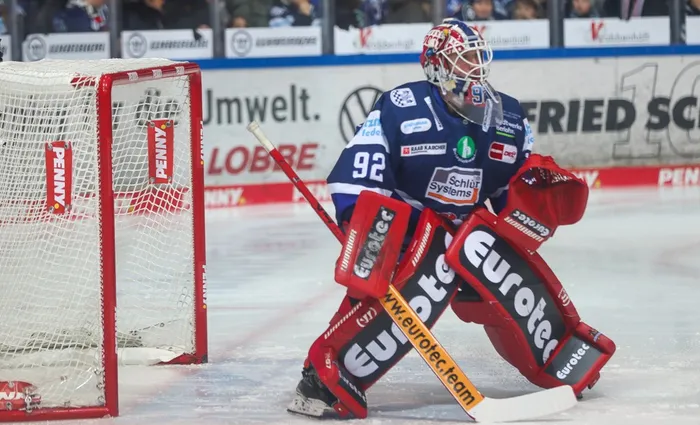 Eishockeytorwart Andreas Jenike in voller Ausrüstung vor dem Tor, bereit zum Abwehren.