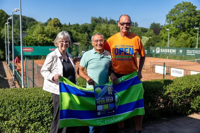 Sabine Wallmann, Erol Altun und Stefan Thomeier präsentieren ein Banner für die MTC/TC Halver Open 2026 vor einem Tennisplatz.