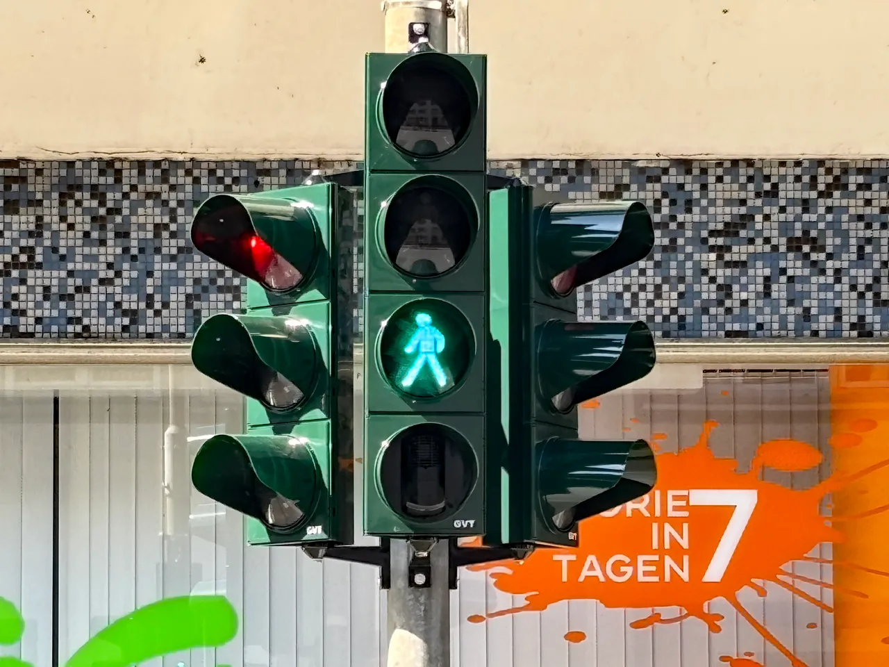 Grüne Fußgängerampel mit leuchtendem Symbol eines gehenden Mannes.