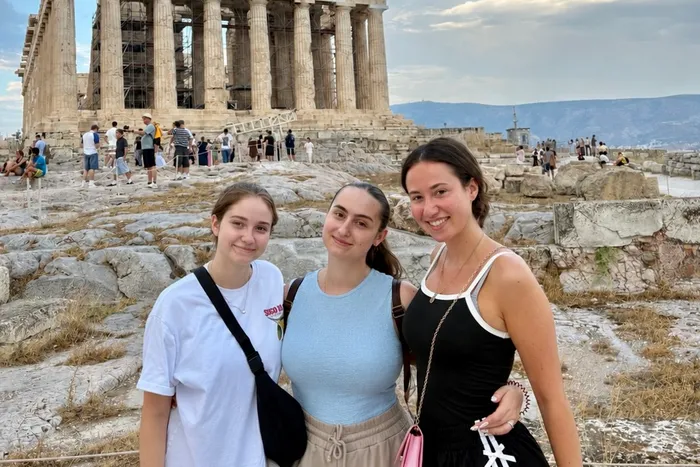 Lea Lemke, Soi Stamenitou und Katarina Alilovic posieren vor der Akropolis in Athen.