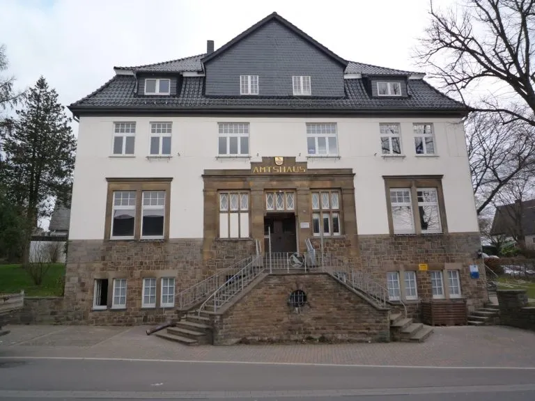 Zwei­stöckiges Gebäude mit grauem Schieferdach und dem Schriftzug „Amtshaus“ über dem Eingang. Es dient als Museum, darunter das Bakelitmuseum in Kierspe.
