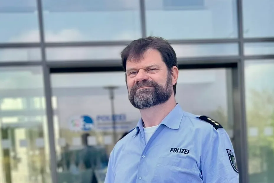 Dirk Happe, neuer Abteilungsleiter der Polizei im Ennepe-Ruhr-Kreis, im Dienst vor einem modernen Glasgebäude.