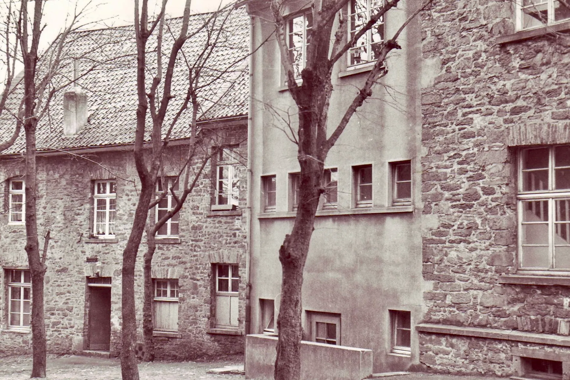 Das ehemalige Hauptgebäude der Realschule in Breckerfeld, heute Melanchthon-Haus, mit Fassaden aus Stein und Putz und mehreren Fenstern.