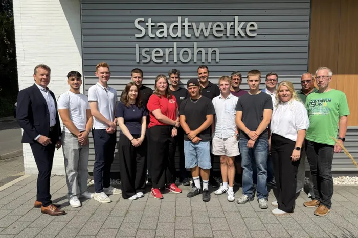 Eine Gruppe von Personen steht vor dem Gebäude der Stadtwerke Iserlohn.