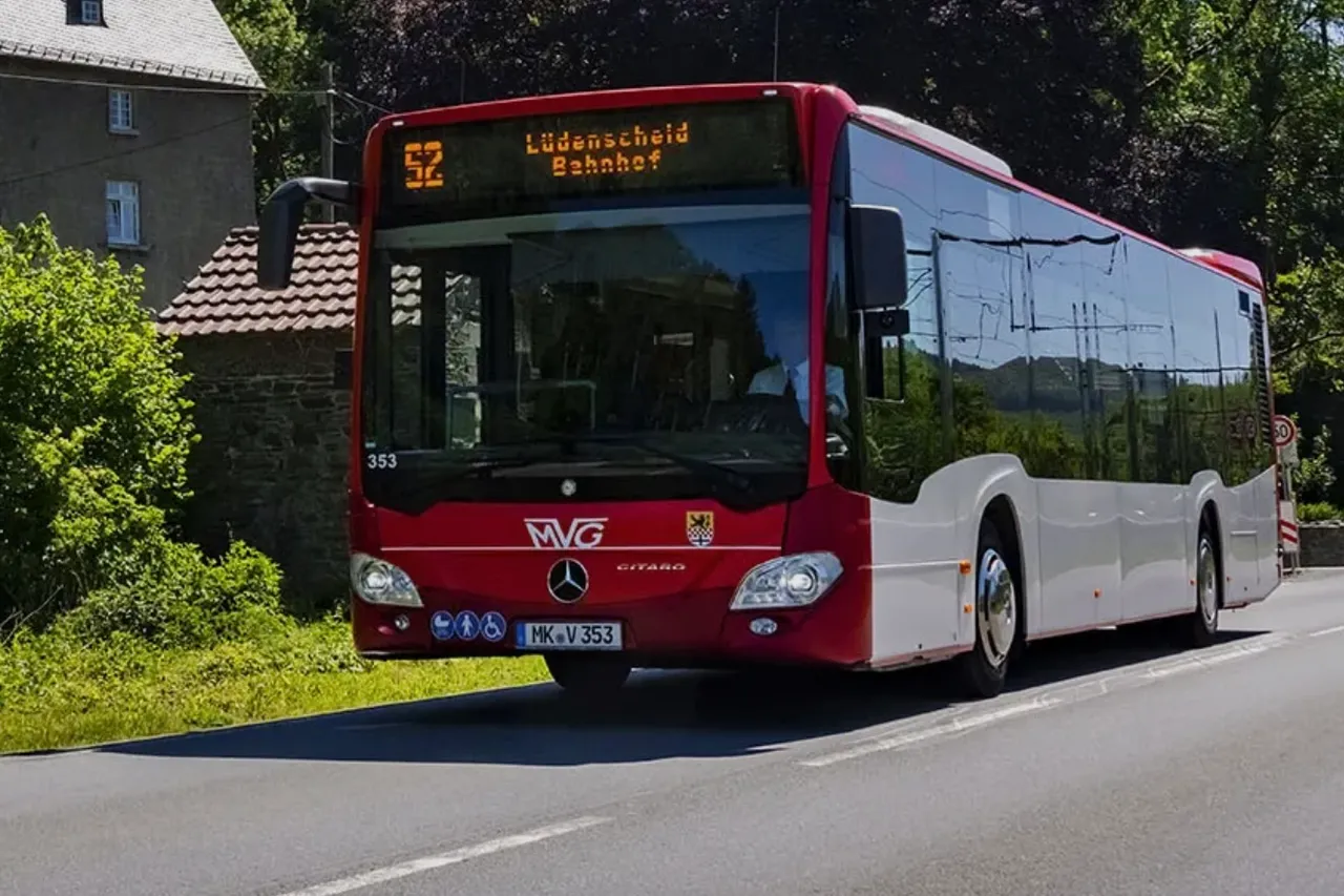 Ein rot-weißer MVG-Bus der Linie 52 mit der Zielanzeige „Lüdenscheid Bahnhof“ fährt auf einer Straße.