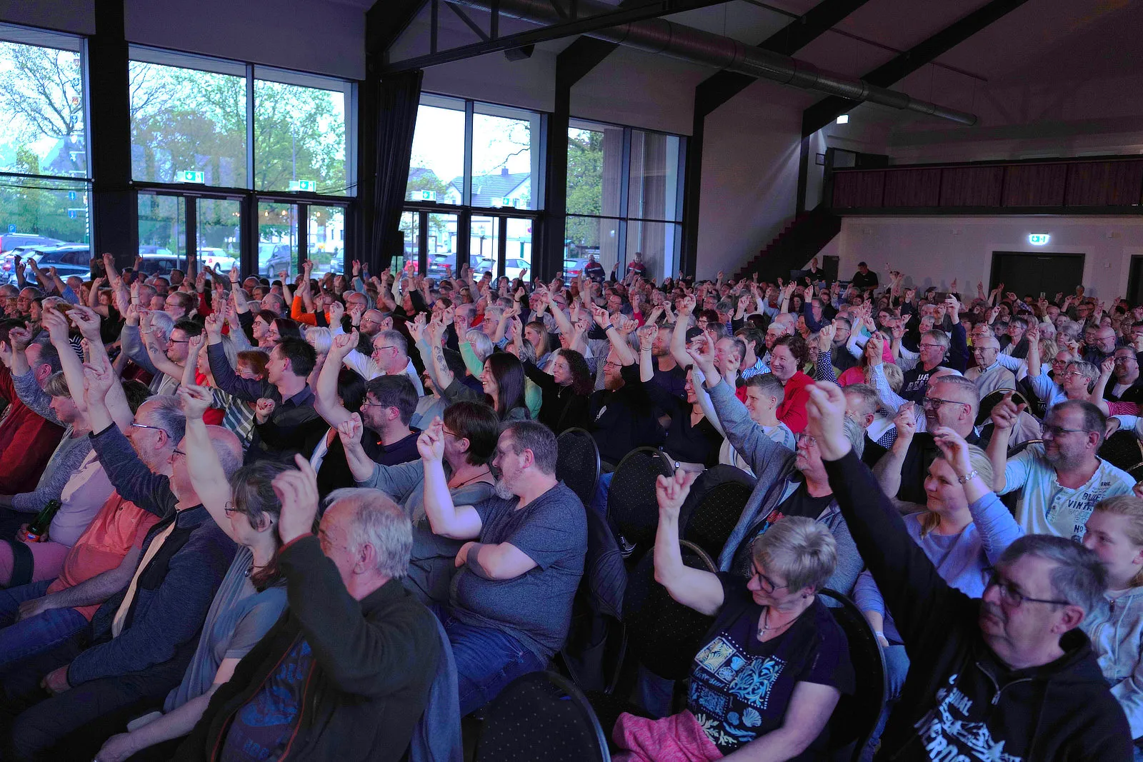 Volles Publikum bei der Improvisationsshow „Gute Frage“ mit Wigald Boning und Bernhard Hoëcker in der Herscheider Gemeinschaftshalle, viele Zuschauer heben die Hände.