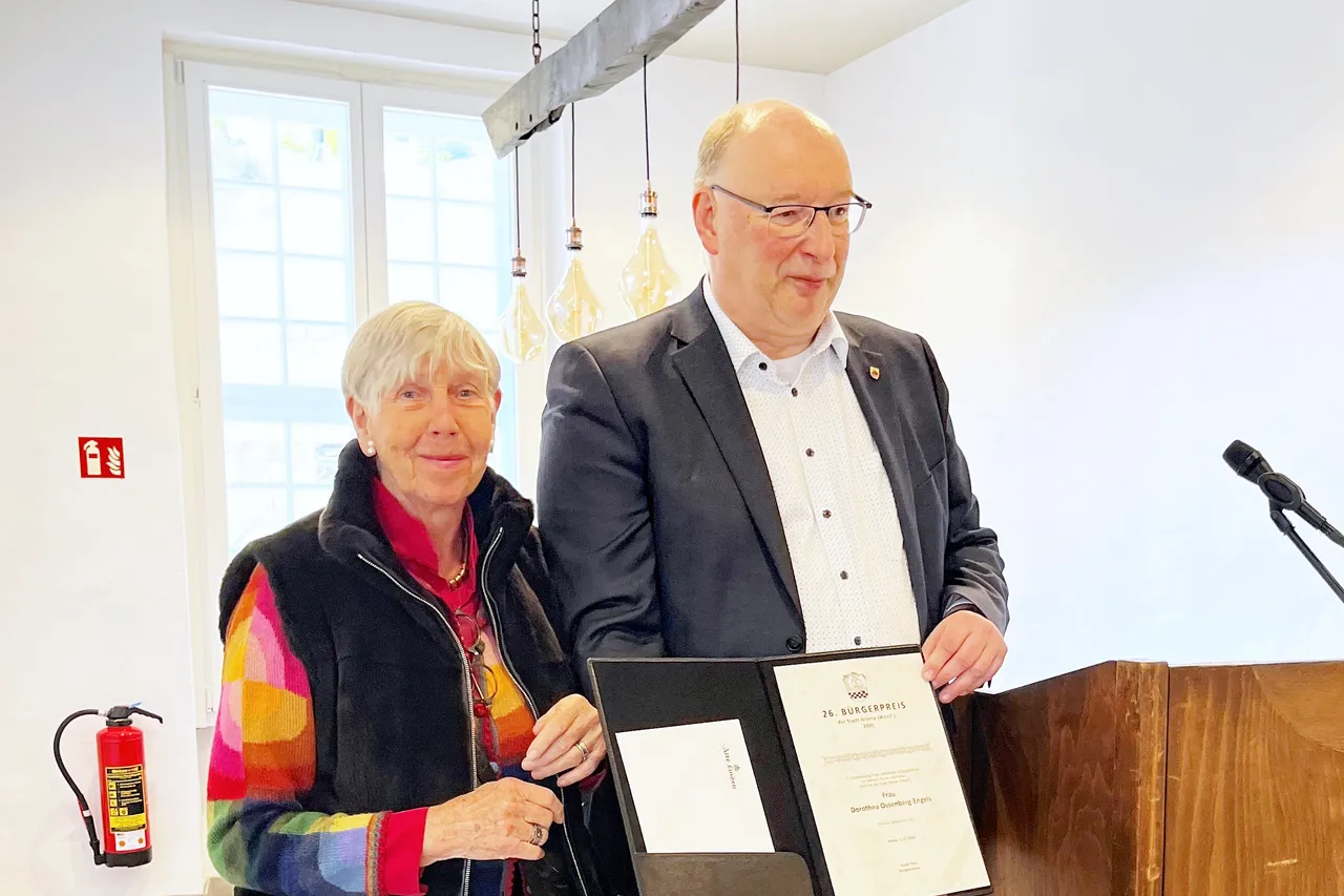 Bürgermeister Guido Thal überreicht Dorothea Ossenberg-Engels eine Urkunde für ihr Engagement in Stadt Altena.