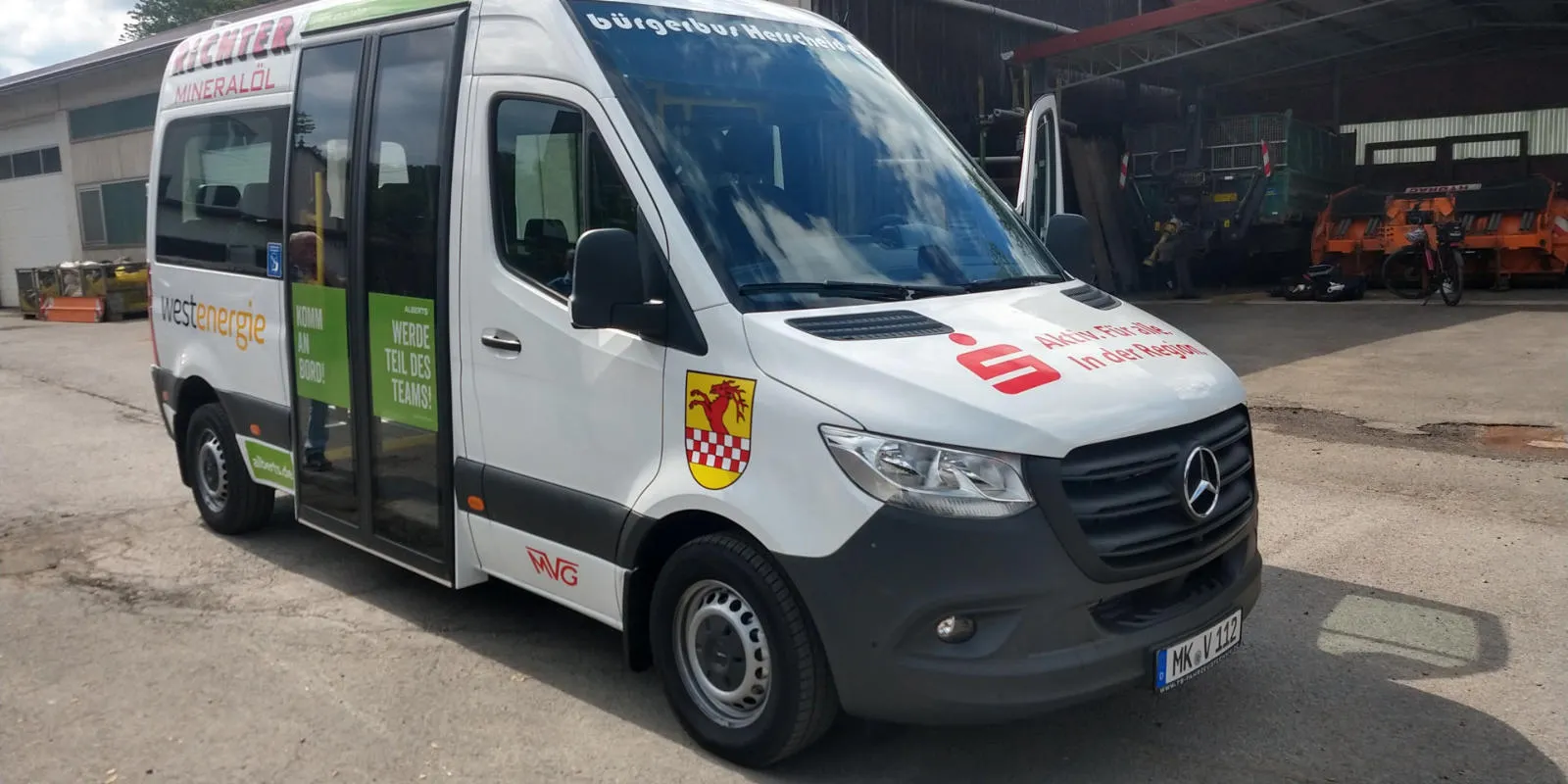 Weißer barrierearmer Niederflurbus mit dem Wappen von Herscheid und der Aufschrift „Aktiv für alle in der Region“.