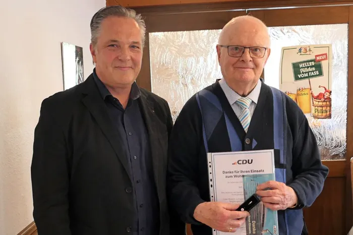 Zwei Männer im Anzug posieren nebeneinander. Der rechte Mann hält eine Urkunde der CDU mit der Aufschrift „Danke für Ihren Einsatz zum Wohl“.