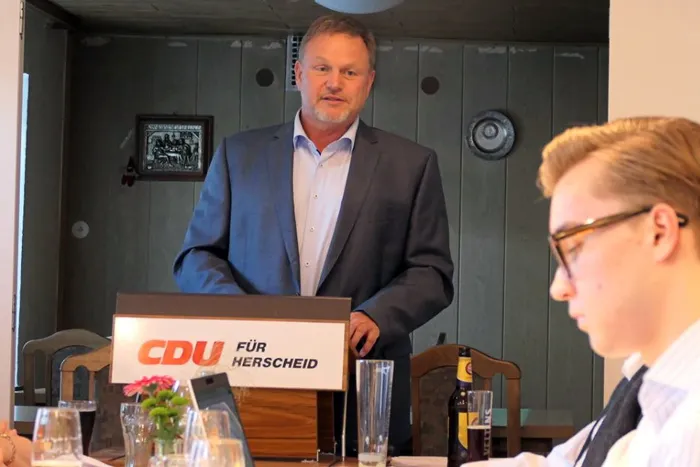 Peter Schrade spricht auf einer CDU-Veranstaltung in Herscheid vor einem Publikum. Auf dem Rednerpult steht das CDU-Logo mit dem Zusatz „für Herscheid“.