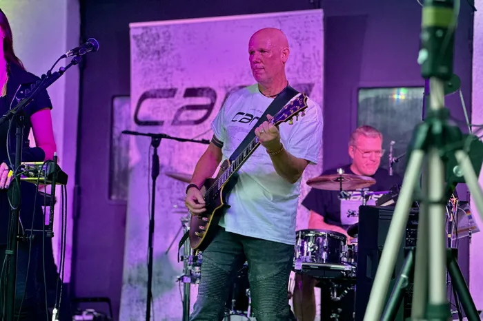 Ein Mann spielt eine dunkle E-Gitarre auf der Bühne während des Abschiedskonzerts der Band Cane.