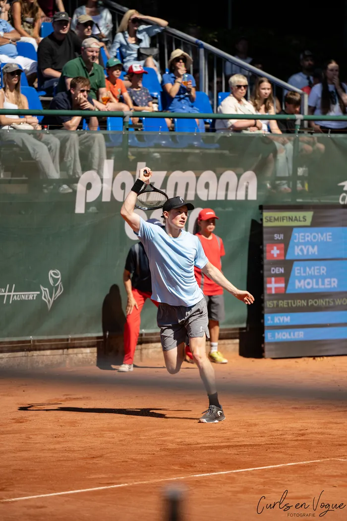 Elmer Møller spielt auf einem Sandplatz während eines Tennis-Halbfinales vor Zuschauern.