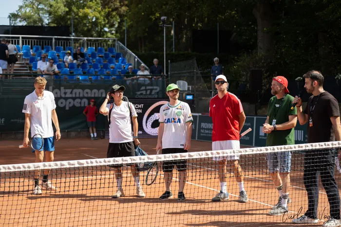 Männer stehen auf einem Sandplatz hinter dem Tennisnetz bei den Platzmann Open 2026.