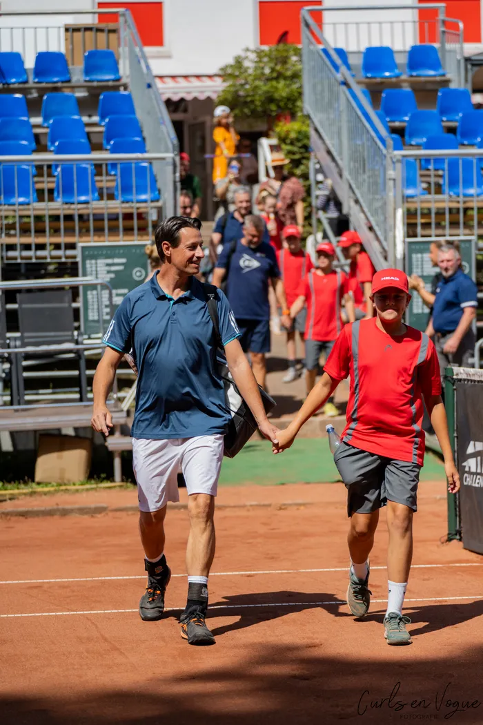 Zwei Männer gehen Hand in Hand über einen Sandplatz bei den Platzmann Open 2026.