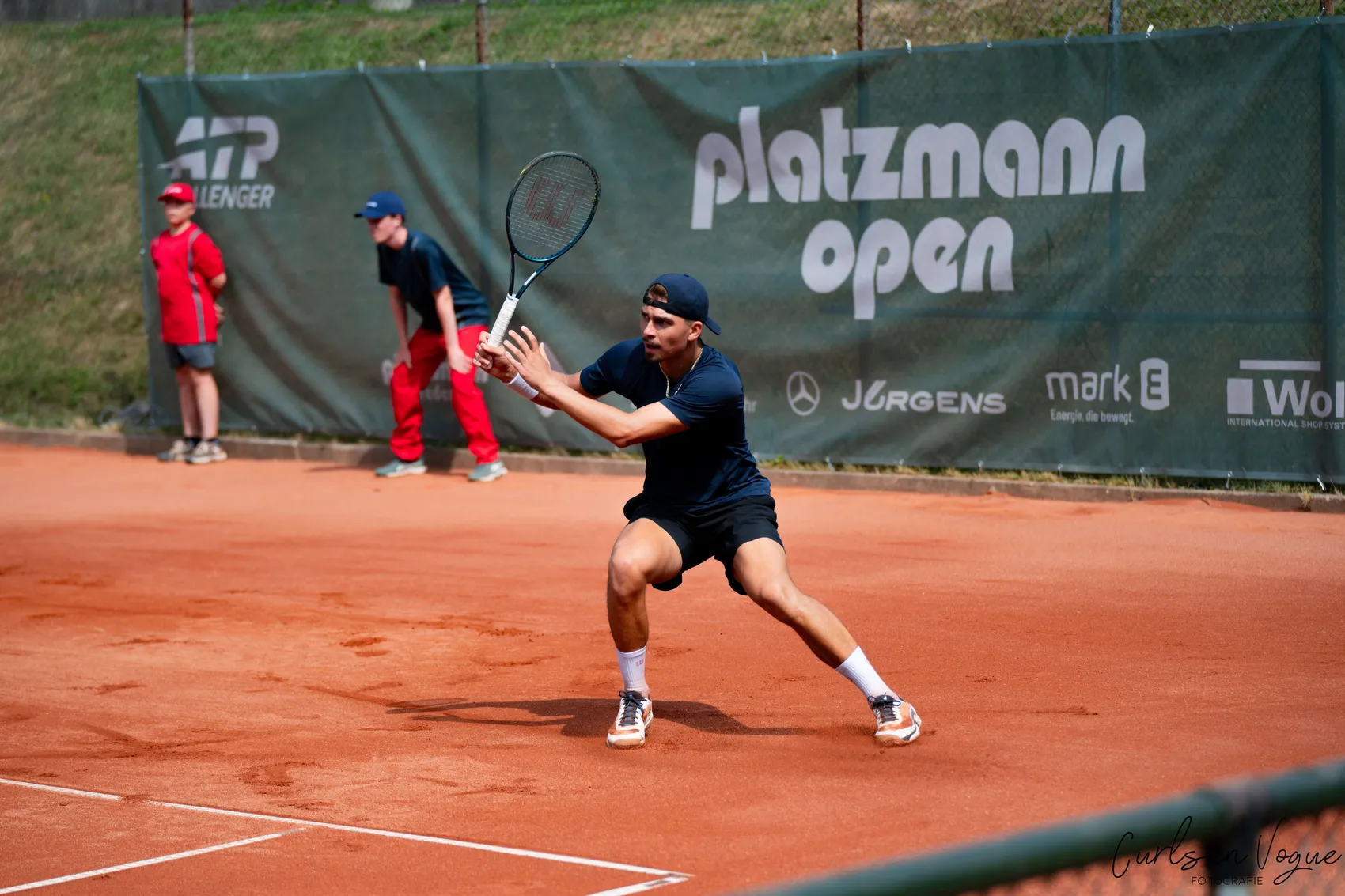 Marko Topo bereitet auf einem Sandplatz einen Schlag mit dem Tennisschläger vor.