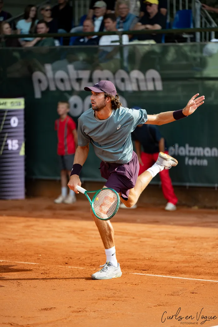 Henri Squire in einer tiefen Ausfallschritt-Bewegung auf einem Sandplatz während eines Tennisspiels bei den Platzmann Open.