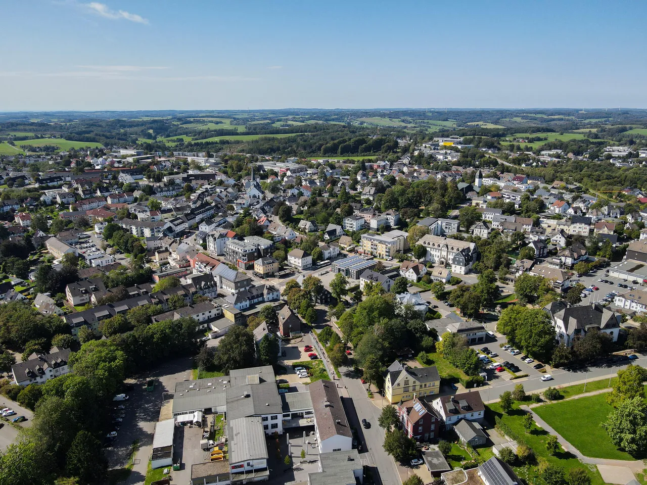 Luftaufnahme der Stadt Halver mit Wohngebäuden, Straßen und viel Grün.