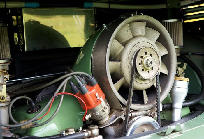 Detailaufnahme des luftgekühlten Motors eines klassischen VW-Busses, mit Kühlgebläse und Zündanlage.