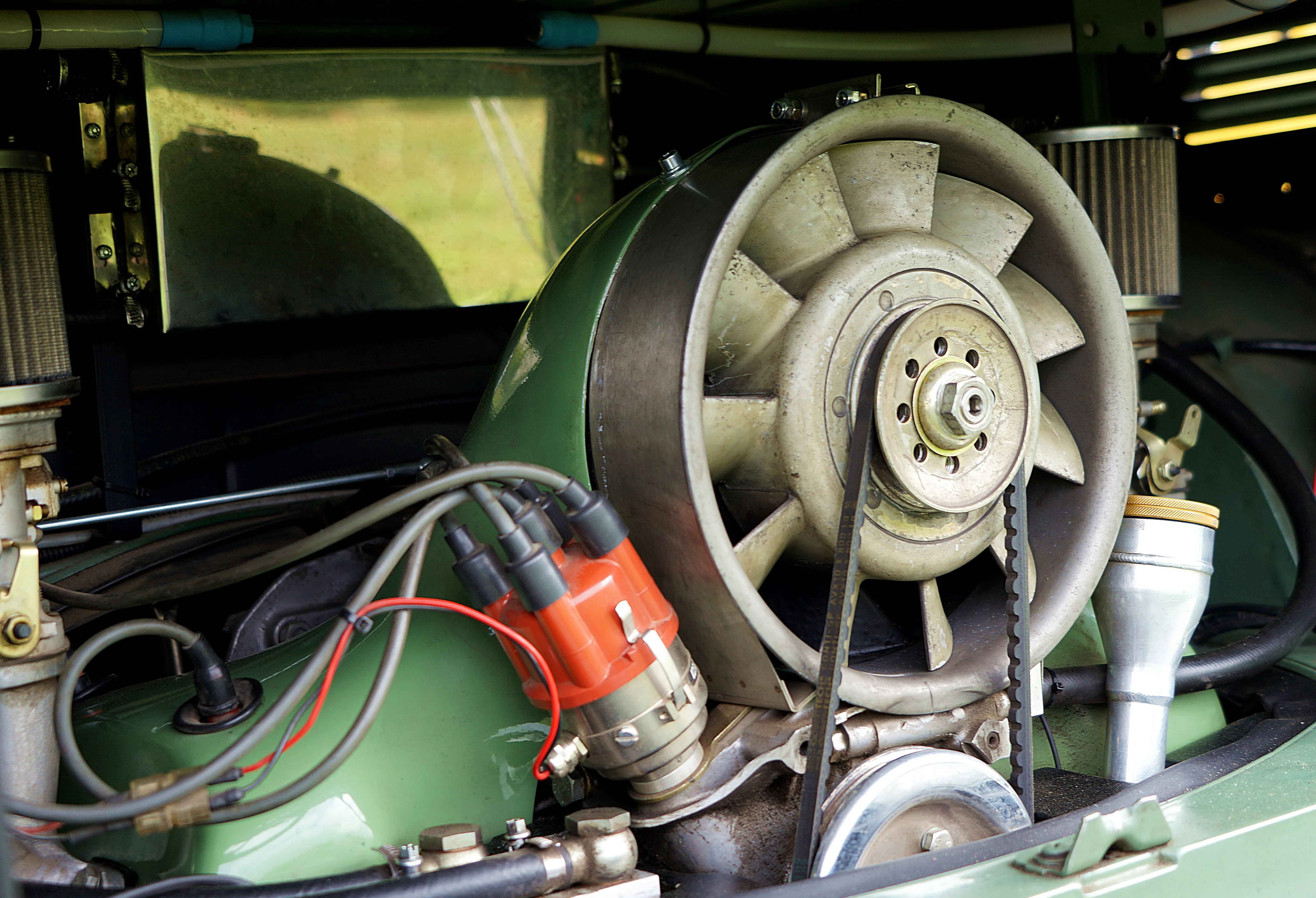 Detailaufnahme des luftgekühlten Motors eines klassischen VW-Busses, mit Kühlgebläse und Zündanlage.