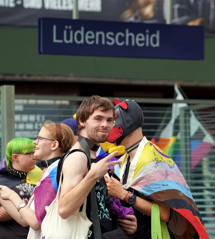 Teilnehmende des Christopher Street Day in Lüdenscheid mit Regenbogenfarben und einer schwarzen Maske.